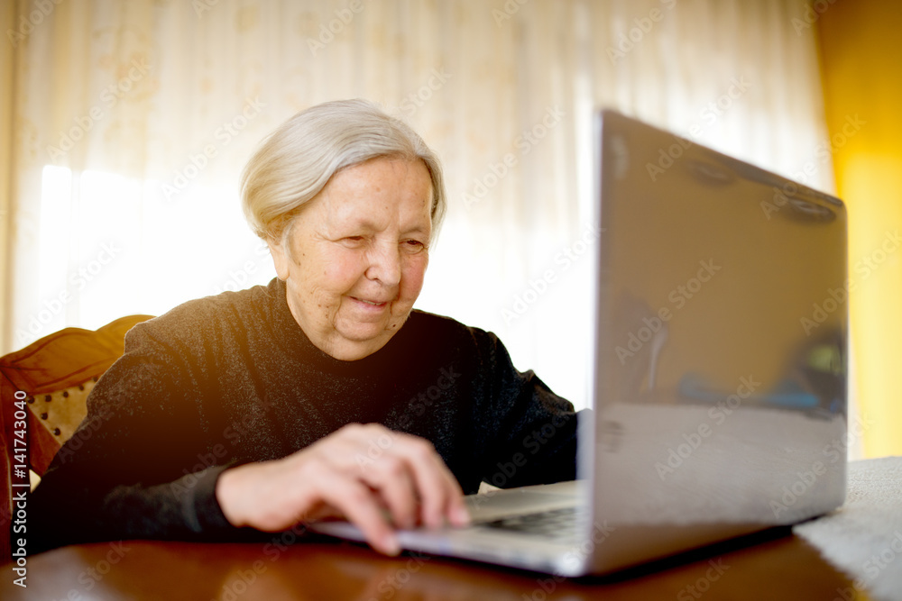 Old senior woman surfing internet on laptop typing on keyboard. Old senior woman surfing internet on laptop typing on keyboard.
