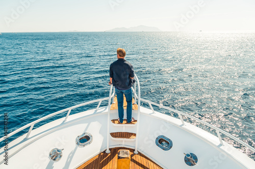 Man on a yacht. Beautiful view from a bow of yacht at seaward. Sailing. Luxury yachts. Boats in sailing regatta. Summer vacation and voyage concept