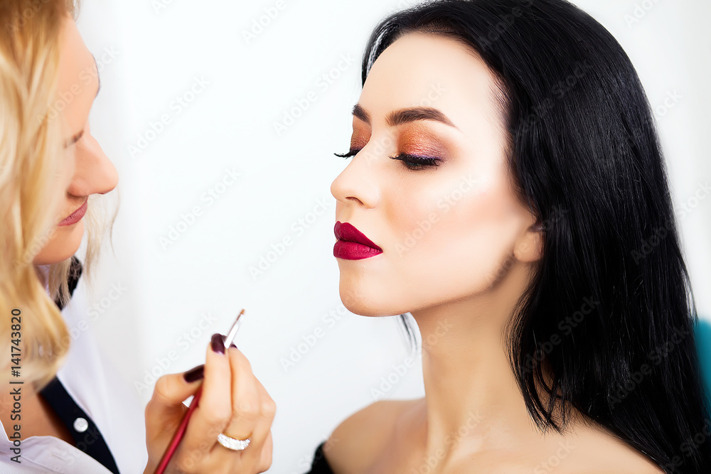 make up artist applying eye shadow to a woman make up artist applying eye shadow to a woman