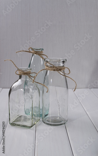 Three glass empty bottles for flowers © Iryna