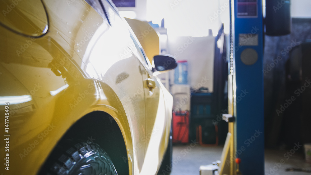 Yellow car in garage auto service - diagnostics and repairing Yellow car in garage auto service - diagnostics and repairing