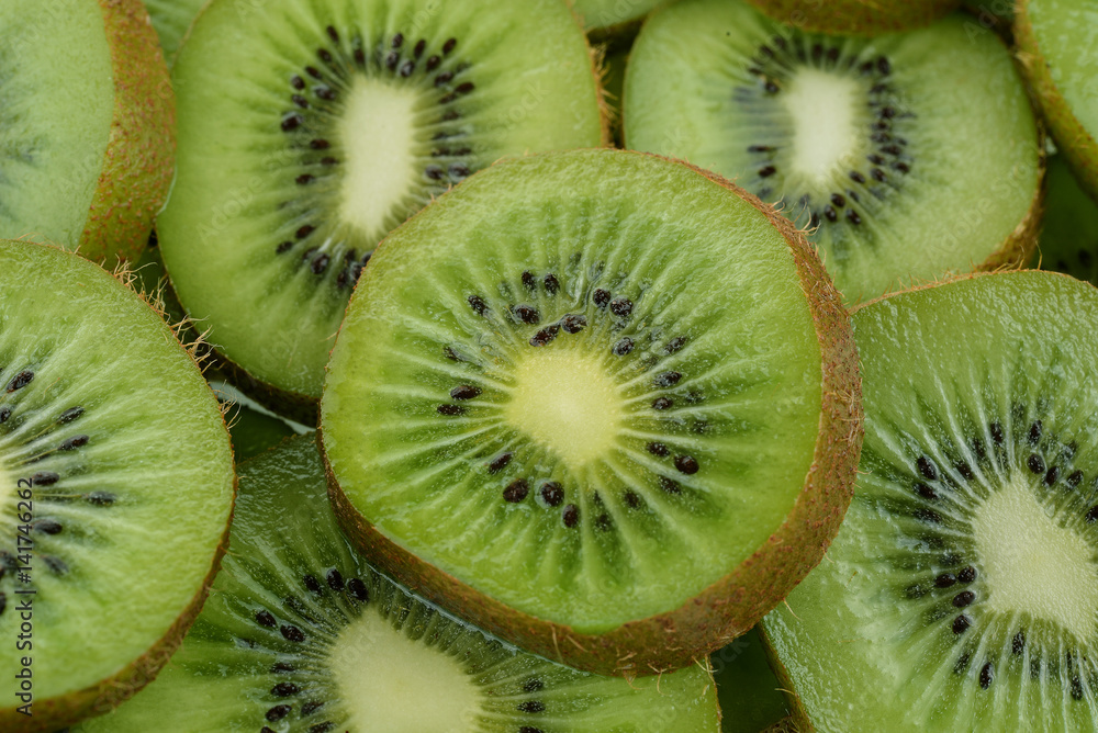 slice of green kiwi with white center and black seeds slice of green kiwi with white center and black seeds