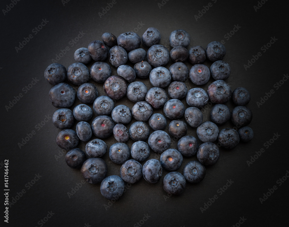 Natural looking blueberries on dark background. Top view. Selective focus in the middle. Natural looking blueberries on dark background. Top view. Selective focus in the middle.
