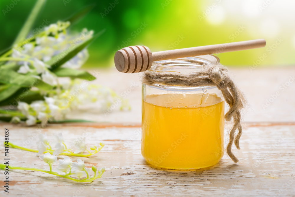 Honey in jar on wooden table Honey in jar on wooden table