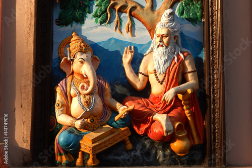 Wall art of Sage Vyasa dictating the story to help God Ganesha to write Hindu epic in temple