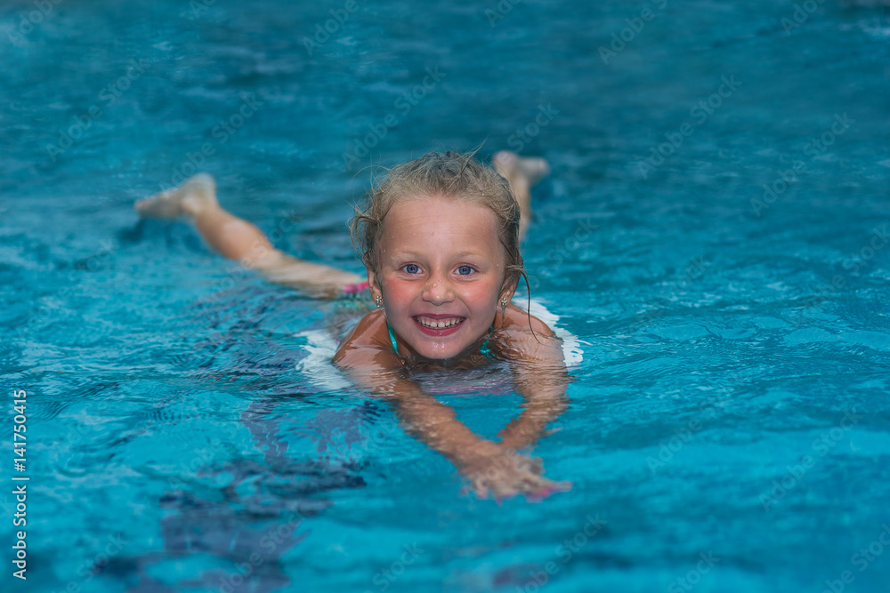 Little girl learning to swim in big sport pool. Swimming school for small children. Healthy kid enjoying active lifestyle. Preschooler practicing with foam pad.