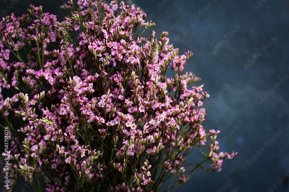 Bouquet of tiny pink flowers on dark moody setting, soft focus Bouquet of tiny pink flowers on dark moody setting, soft focus