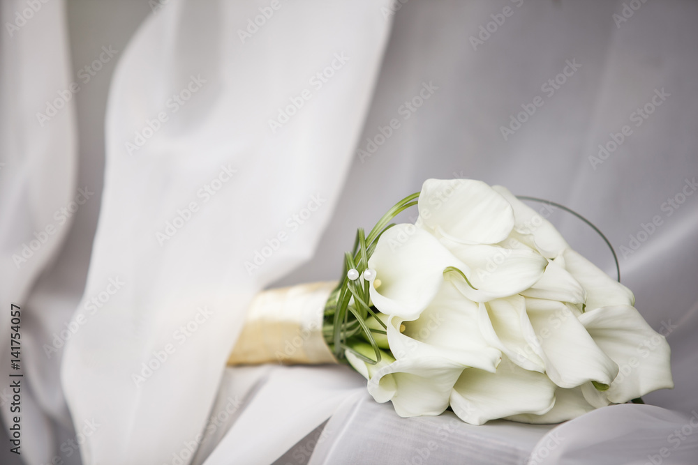 Elegant bridal bouquet of white calla lilies, boutonniere on the table Elegant bridal bouquet of white calla lilies, boutonniere on the table