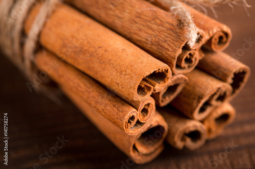 Cinnamon sticks and meal close up on wooden table. Cinnamon sticks spice close up background. Texture of cinnamon sticks.