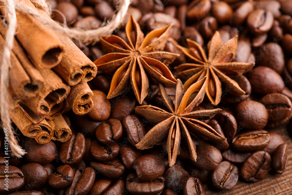 Coffee beans and cinnamon on a background of burlap. Roasted coffee beans background close up. Coffee beans pile from top with copy space for text. Seasoning. Spice. Cinnamon. Badian. Coffee house. Coffee beans and cinnamon on a background of burlap. Roasted coffee beans background close up. Coffee beans pile from top with copy space for text. Seasoning. Spice. Cinnamon. Badian. Coffee house.