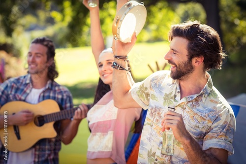Foto Man holding beer bottle and playing tambourine