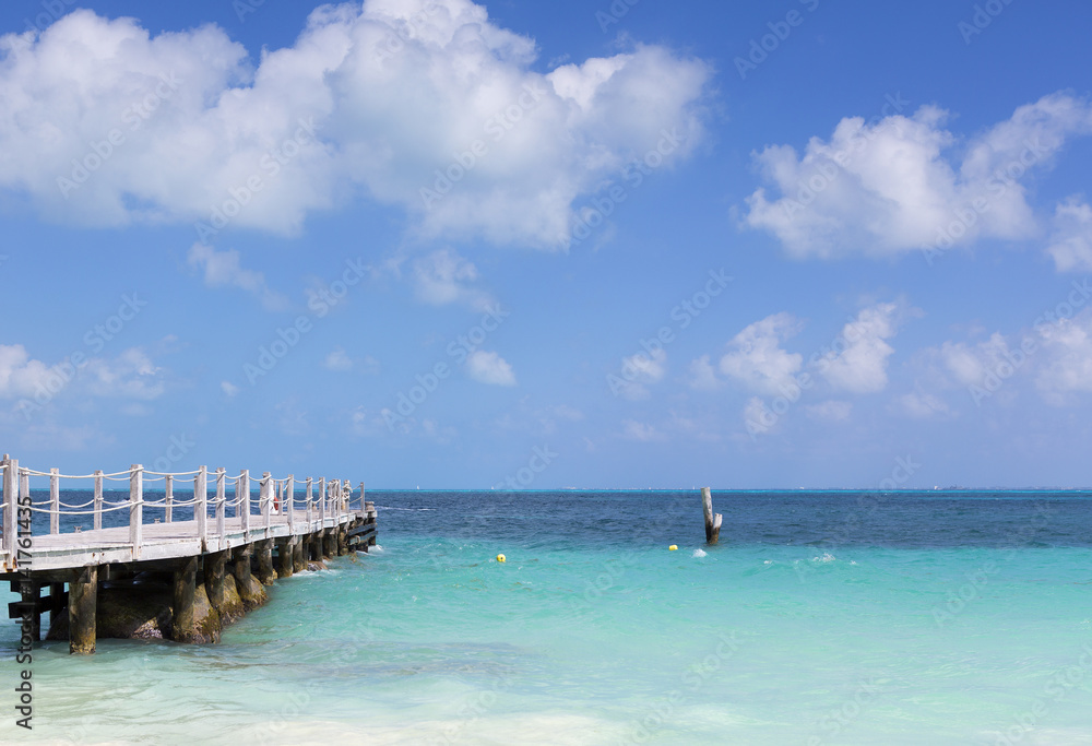 Long wooden dock on the shore of the Caribbean sea.