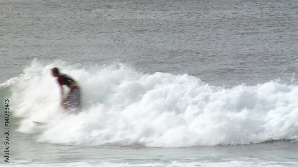 Surfer does a sharp turn to catch an incoming wave Surfer does a sharp turn to catch an incoming wave