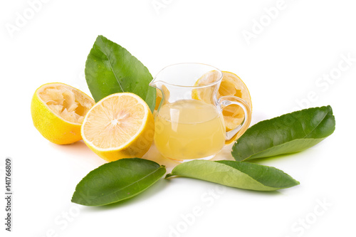 Photos glass bowl of freshly squeezed lemon juice, lemon squeezer and ripe lemons on wh