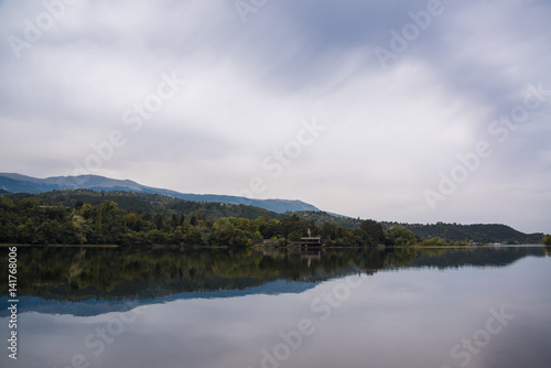 Landscape with lake, forest on the slope of a hill and cloudy sky. Pancharevo. Sofia, Bulgaria