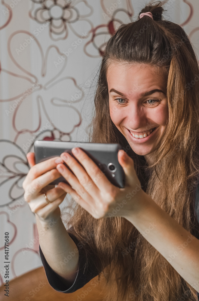 Emotion of joy for a girl with a phone in her hands Emotion of joy for a girl with a phone in her hands