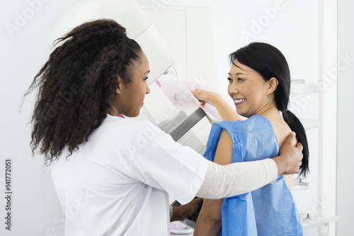 Happy Woman Looking At Doctor While Undergoing Mammogram X-ray T photo