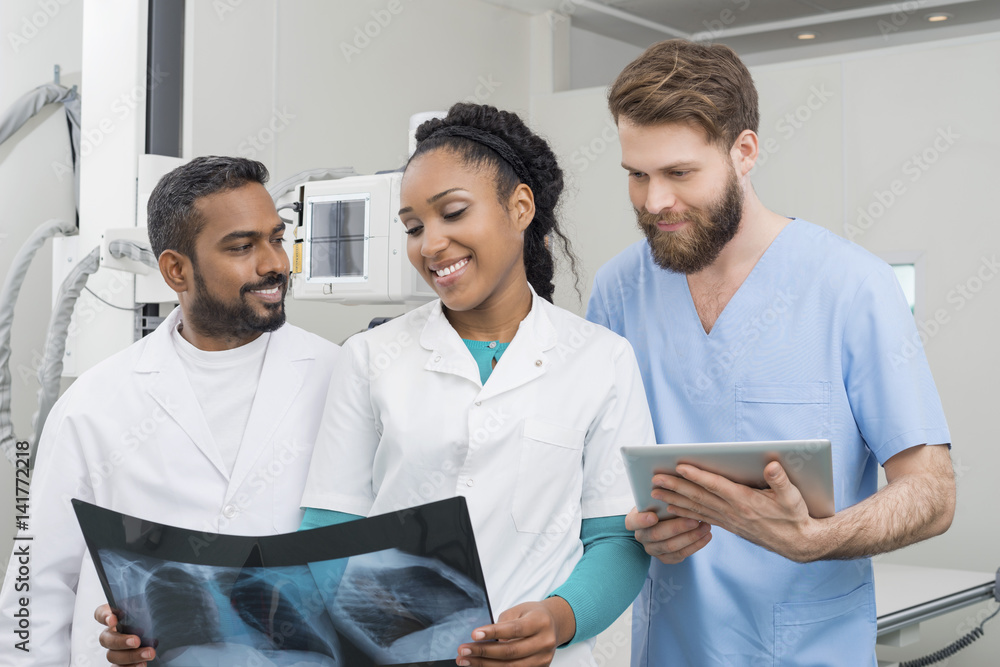 Medical Professionals With Chest X-ray And Digital Tablet In Hos Medical Professionals With Chest X-ray And Digital Tablet In Hos