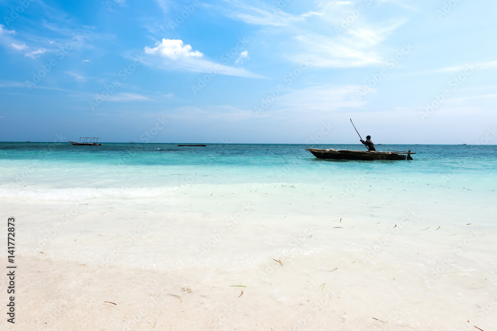 landscape with man in a boat in ocean near African shore landscape with man in a boat in ocean near African shore