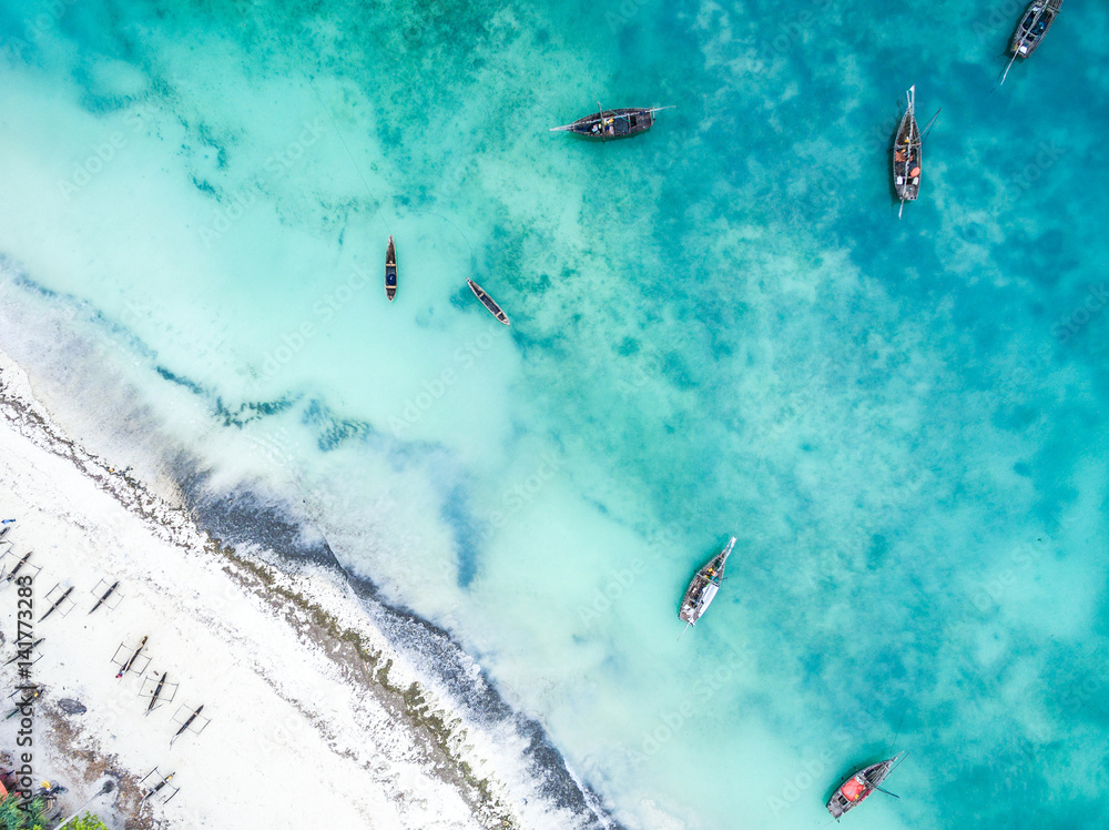 top view of ocean with fishing boats and islad city coastline on Zanzibar, aerial photo - obrazy, fototapety, plakaty 