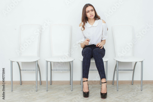 A beautiful girl is sitting on chair and angry