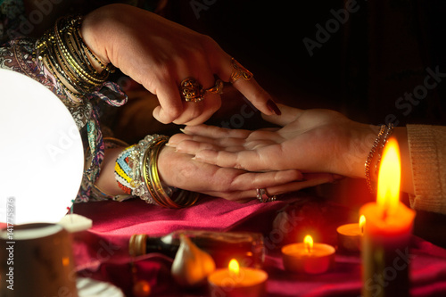 Gypsy woman reading future from another womans palm