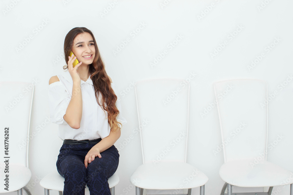 Young business woman sitting on chair and using mobile phone Young business woman sitting on chair and using mobile phone