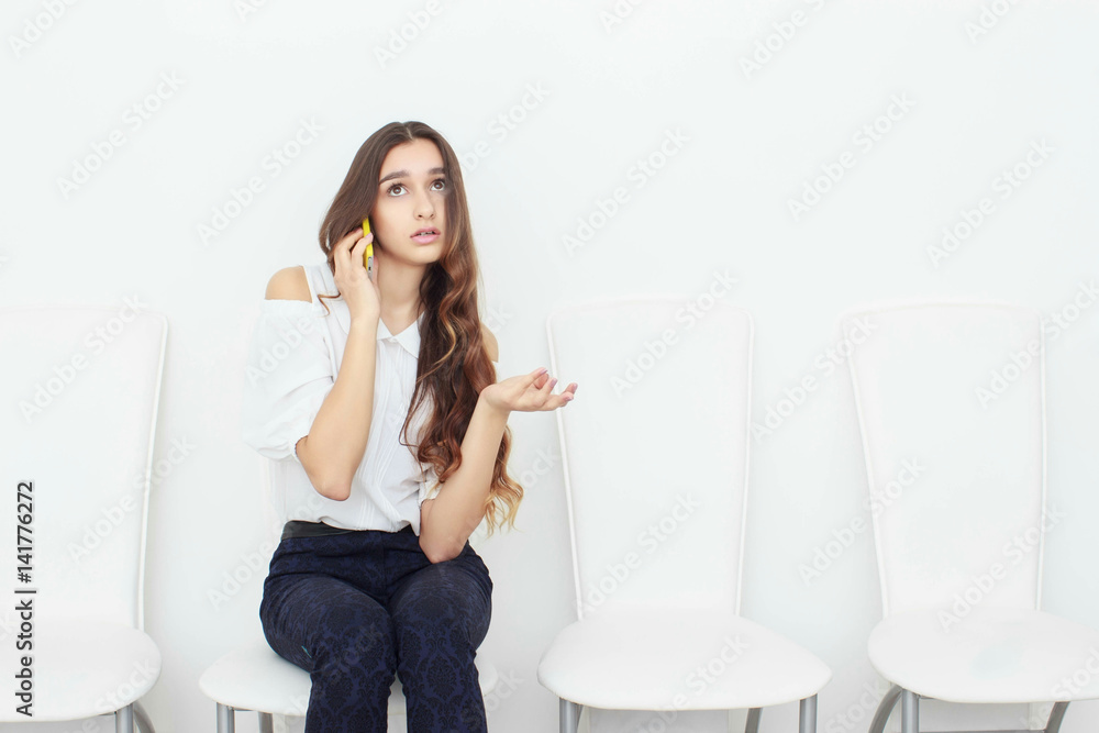 Young business woman sitting on chair and using mobile phone Young business woman sitting on chair and using mobile phone