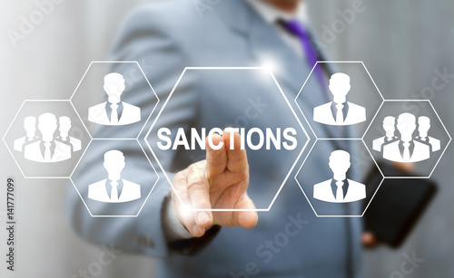 Sanctions Business concept. Man touched sanction icon on virtual screen on background of network people, businessman. Political and economic measures of deterrence countries. Embargo government photo