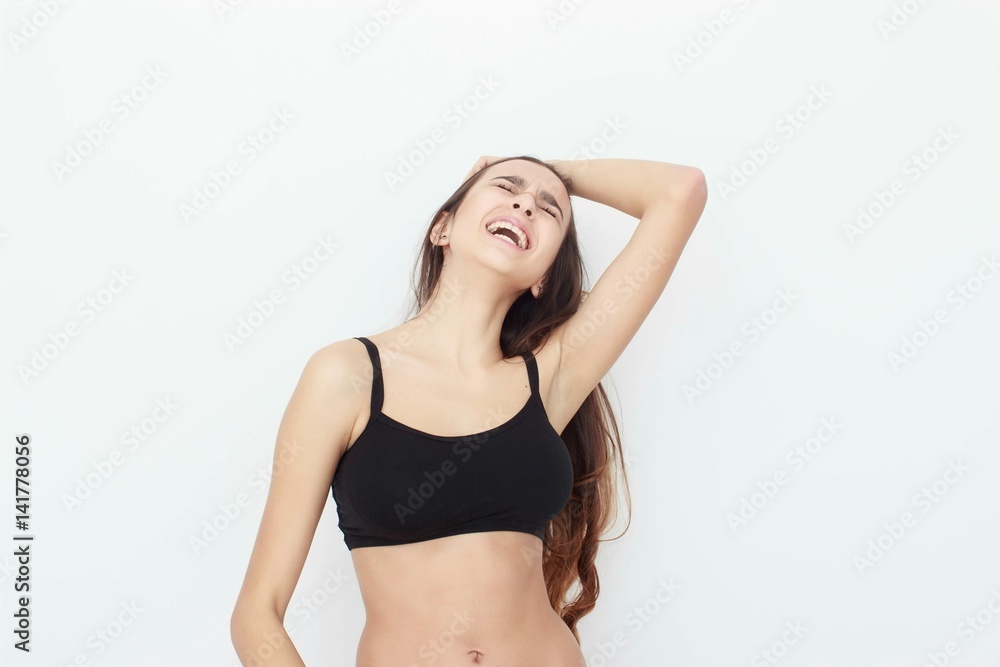 Fototapeta premium Beautiful girl in black top on white background shows emotion