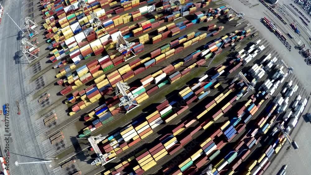Aerial flight over harbor container terminal showing universal containers from above colorful landscape showing shipping containers from above used for importing and exporting goods via road or sea 4k Aerial flight over harbor container terminal showing universal containers from above colorful landscape showing shipping containers from above used for importing and exporting goods via road or sea 4k