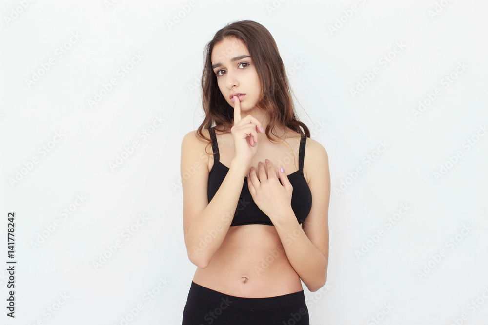 Beautiful girl in black top on white background shows emotion Beautiful girl in black top on white background shows emotion