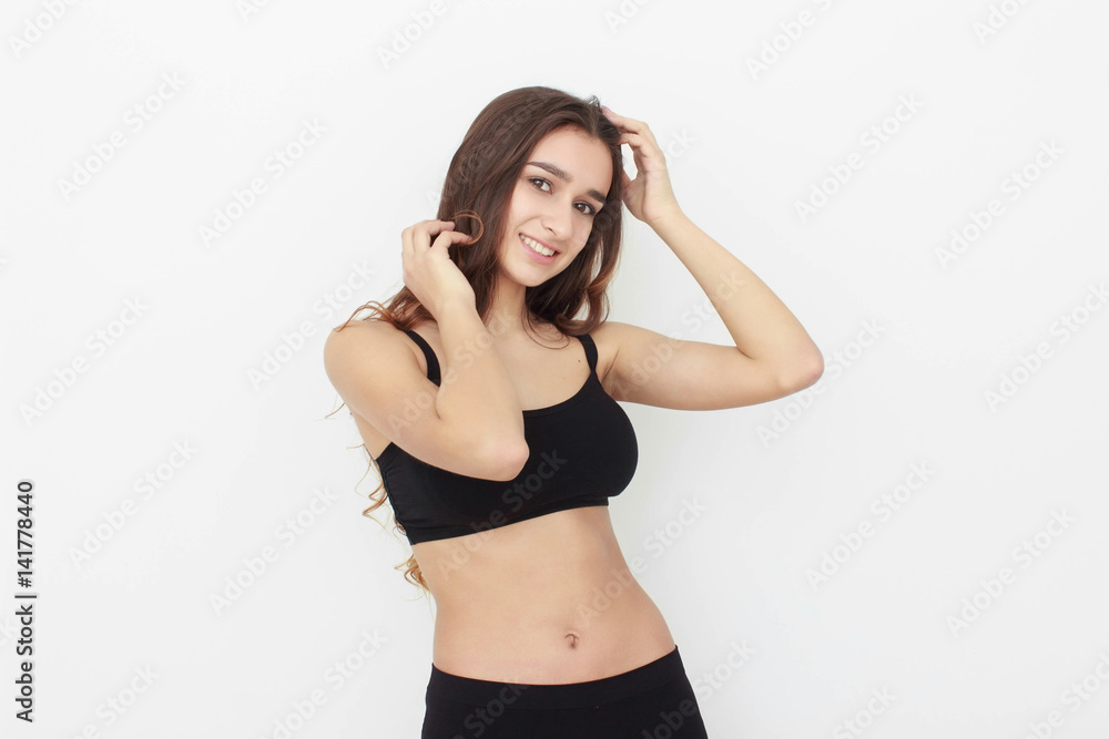 Obraz premium Beautiful girl in black top on white background shows emotion