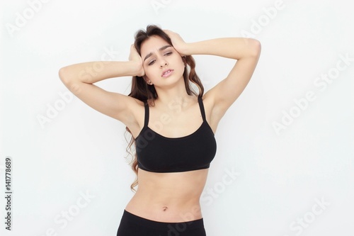Beautiful girl in black top on white background shows emotion © Saksoni
