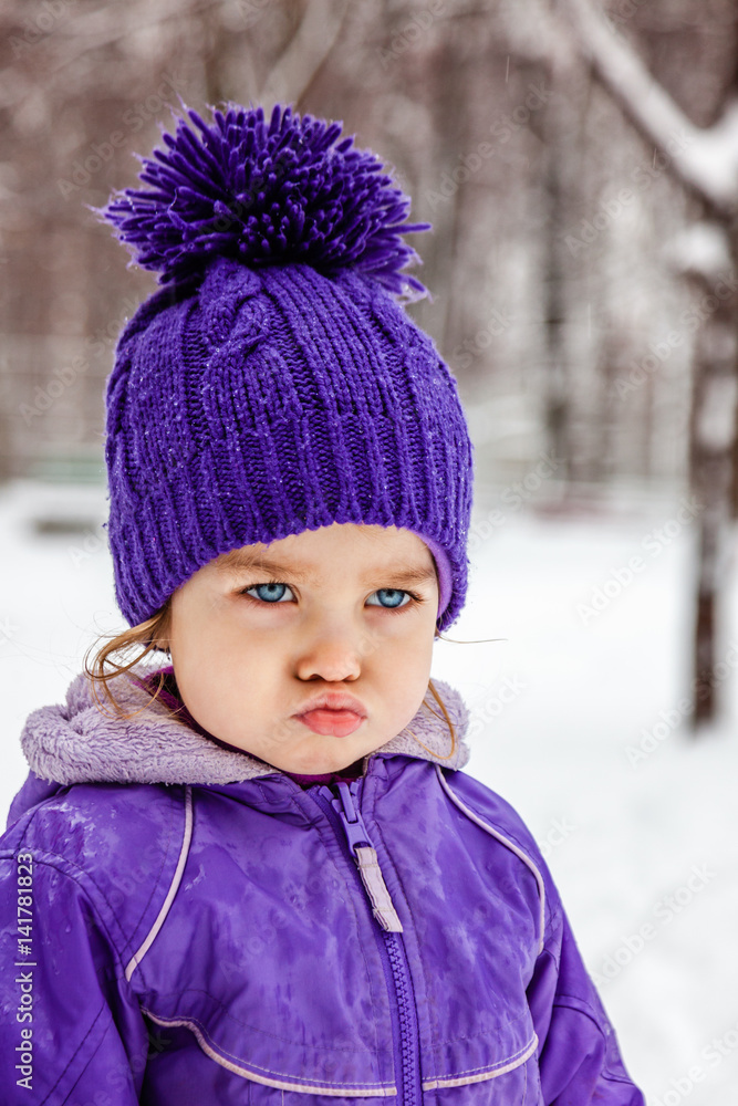 Angry little girl emotional portrait, closeup. Child walking outside. Snow winter. Angry little girl emotional portrait, closeup. Child walking outside. Snow winter.