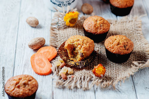 hearty and healthy breakfast, lunch, pastries, carrot cupcakes with raisins, candied fruits, nuts and green tea on a wooden background 
