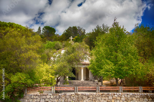 A small old church hidden among the trees of an olive grove in Caldas de Monchique, Portugal