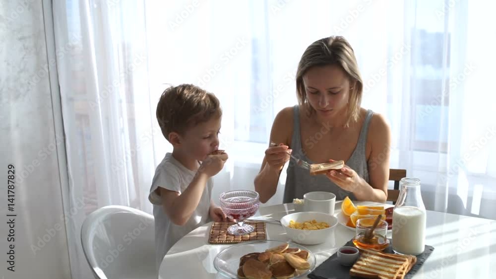 young girl and cute boy eating Breakfast. eat toast and pancakes young girl and cute boy eating Breakfast. eat toast and pancakes