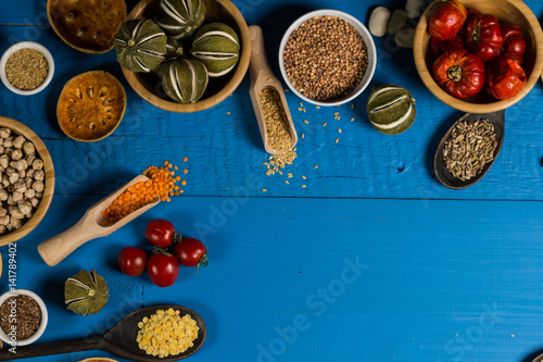 Bowls and spoons of various legumes on wooden table © Aerial Mike