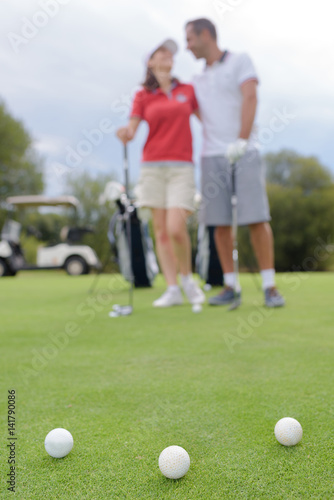 couple standing on golf course