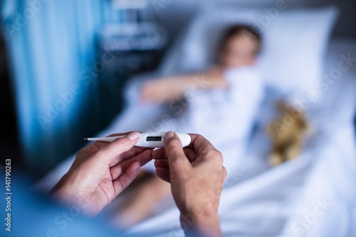 Foto Female doctor holding thermometer at hospital