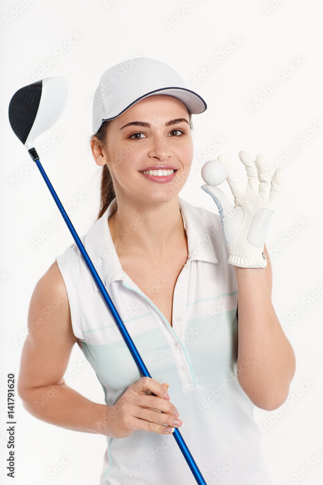 Pretty woman golfer posing with golf club and ball on white background in studio Pretty woman golfer posing with golf club and ball on white background in studio