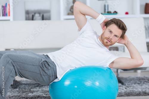 young man exercises on the fitness ball