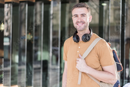 Man close up with headphones and back pack smiling © DavidPrado