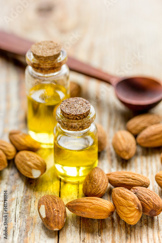 spa with almond oil in organic cosmetic set on wooden background