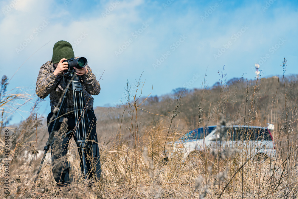 Photographer man taking pictures of animals in the wild Photographer man taking pictures of animals in the wild