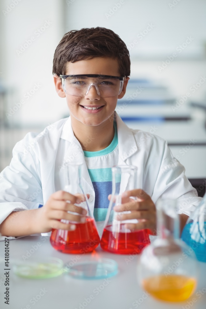 Portrait of schoolboy doing a chemical experiment in laboratory Portrait of schoolboy doing a chemical experiment in laboratory