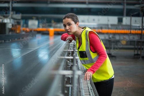 Cuadro en lienzo Female factory worker checking conveyor belt