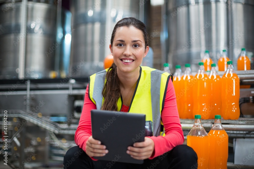 Female factory worker holding digital tablet Female factory worker holding digital tablet