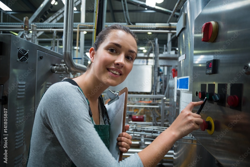 Female factory worker operating machine Female factory worker operating machine